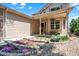 Inviting front yard featuring a cozy porch and colorful flowerbeds set against a stone border at 14191 W Amherst Ave, Lakewood, CO 80228