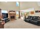 Bright open-concept living room with a fireplace and views of the kitchen and backyard at 14191 W Amherst Ave, Lakewood, CO 80228