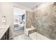 Modern bathroom with glass enclosed shower, tile surround, and view into the primary bedroom at 3441 N Denali St, Aurora, CO 80019