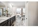 Bright bathroom boasting a dual sink vanity, tiled floors, and a large glass enclosed shower at 3441 N Denali St, Aurora, CO 80019