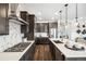 Well-designed kitchen featuring dark wood cabinets, stainless steel appliances, and a stylish backsplash at 3441 N Denali St, Aurora, CO 80019