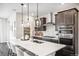 Bright, modern kitchen featuring an island with seating, stainless appliances and dark cabinetry at 3441 N Denali St, Aurora, CO 80019