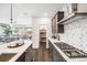 Beautiful kitchen with a view, dark cabinets, pantry, stainless appliances, and stylish backsplash at 3441 N Denali St, Aurora, CO 80019