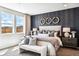 Main bedroom with king bed, window seating, and dark accent wall at 3441 N Denali St, Aurora, CO 80019