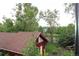 View of a backyard with lush trees, a rustic red outbuilding, and picnic table at 1647 N Osceola St, Denver, CO 80204