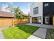 Modern home showcases a lush, fenced backyard with a concrete patio, perfect for outdoor enjoyment at 1647 N Osceola St, Denver, CO 80204
