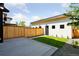 A modern home shows off the large backyard with healthy grass, and a concrete patio at 1647 N Osceola St, Denver, CO 80204