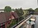 Balcony view with outdoor seating, overlooking neighborhood rooftops and tree tops at 1647 N Osceola St, Denver, CO 80204