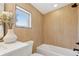 Modern bathroom featuring tile walls, a bathtub, and a window at 1647 N Osceola St, Denver, CO 80204