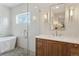 The bright bathroom features a soaking tub, glass enclosed shower, and a wood vanity with marble countertop at 1647 N Osceola St, Denver, CO 80204