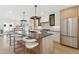 Modern kitchen featuring a large island with seating, stainless steel appliances, and designer finishes at 1647 N Osceola St, Denver, CO 80204