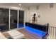 Modern living room with sliding doors to a deck and built-in storage and blue accent lighting at 1647 N Osceola St, Denver, CO 80204