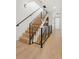 Admire this well-lit staircase with wood steps, black railing, and modern light fixtures at 1647 N Osceola St, Denver, CO 80204
