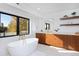 Bright bathroom with a soaker tub, marble floors, wood cabinets, and a window to the outside at 1374 S Vine St, Denver, CO 80210