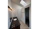 Well-lit bathroom features a vanity with granite countertop, a skylight, and a walk-in shower, creating a functional space at 4362 Denmark Ct, Denver, CO 80239