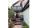 Inviting home entrance with a striking black door, complemented by a dark wood balcony, and wood stairs at 4362 Denmark Ct, Denver, CO 80239