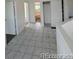 Bright hallway with tiled flooring, featuring a view into a bathroom with white walls and ample natural light at 4362 Denmark Ct, Denver, CO 80239