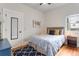 Comfortable bedroom with wood floors, gray headboard, and a sunny window at 3953 Tejon St, Denver, CO 80211