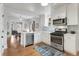 Modern kitchen has stainless appliances and breakfast bar which opens to dining area at 3953 Tejon St, Denver, CO 80211