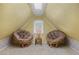 Attic space with yellow walls, skylight, and cozy seating area with two rattan papasan chairs at 8501 W 52Nd Ave, Arvada, CO 80002