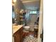 This bathroom has a tub and shower, toilet, vanity and sink, and shelving unit with items stored in baskets at 8501 W 52Nd Ave, Arvada, CO 80002