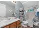 This bathroom has a tub and shower, toilet, vanity and sink, and shelving unit with items stored in baskets at 8501 W 52Nd Ave, Arvada, CO 80002