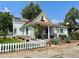 Quaint exterior with a front porch, white picket fence, and well-manicured landscaping at 8501 W 52Nd Ave, Arvada, CO 80002