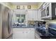 Functional kitchen featuring modern appliances, white cabinetry, and ample counter space at 8501 W 52Nd Ave, Arvada, CO 80002