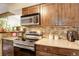 Well-lit kitchen with stainless steel appliances, wooden cabinets, and a modern stove at 10150 E Virginia Ave # 18-302, Denver, CO 80247