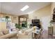Cozy living room with a beautiful stone fireplace, skylight, and comfortable seating arrangement at 10150 E Virginia Ave # 18-302, Denver, CO 80247