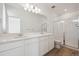 Well-lit bathroom with a double sink vanity, large mirror, and a glass-enclosed shower at 1244 Penner Dr, Erie, CO 80026