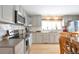 Updated kitchen featuring modern appliances, grey cabinets, and stylish backsplash at 2963 S Ivan Way, Denver, CO 80227