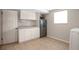 Bright laundry room featuring white cabinets, ample counter space, and a secure safe for valuables at 2963 S Ivan Way, Denver, CO 80227