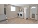 Well-equipped laundry area with modern washer, dryer, storage, and convenient access to an exterior door at 2963 S Ivan Way, Denver, CO 80227