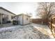 Fenced backyard featuring a shed, grill, concrete patio, and a mix of grass and snow at 327 N 12Th Ave, Brighton, CO 80601