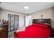 A bedroom is decorated with dark wood furniture, a patterned closet door, and red and white bedding at 327 N 12Th Ave, Brighton, CO 80601