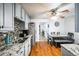 Modern kitchen with stainless steel appliances, granite countertops, hardwood floors, gray cabinets, and an adjacent dining area at 327 N 12Th Ave, Brighton, CO 80601