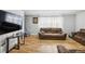 Cozy living room with a large television, two couches, neutral walls and wood flooring at 327 N 12Th Ave, Brighton, CO 80601