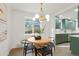 Bright dining area with modern lighting fixture, table, and green cabinets offering a welcoming and stylish space at 211 Newport St, Denver, CO 80220