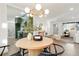 Elegant dining area featuring a modern light fixture, a round table with seating for four, and an open view to the kitchen at 211 Newport St, Denver, CO 80220