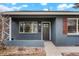 The inviting front entrance of this home features brick detail and large windows on either side of the door at 211 Newport St, Denver, CO 80220