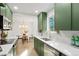 Bright kitchen featuring green cabinets, white countertops, stainless steel appliances and a view into the dining area at 211 Newport St, Denver, CO 80220