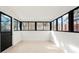 Sunroom with bright white interior, black framed windows, and light wood flooring at 211 Newport St, Denver, CO 80220