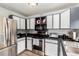 Kitchen with stainless steel appliances, white and gray cabinets, and light wood flooring at 4520 E 112Th Pl, Thornton, CO 80233