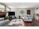Comfortable living room featuring a fireplace, wood floors, a large area rug, and lots of natural light at 4520 E 112Th Pl, Thornton, CO 80233