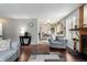 Comfortable living room featuring a fireplace, wood floors, a large area rug, and open layout to the dining area at 4520 E 112Th Pl, Thornton, CO 80233