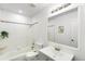 Bright bathroom featuring a shower-tub combo with decorative tile, and vanity with large mirror at 5993 Oneida St, Commerce City, CO 80022