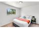 Cozy bedroom with a queen-sized bed, natural light from the window, and modern minimalist decor at 5993 Oneida St, Commerce City, CO 80022