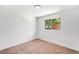 Empty bedroom with neutral carpet, white walls, and a window providing natural light at 5993 Oneida St, Commerce City, CO 80022