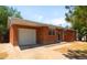 Charming brick home featuring an attached garage, a well-maintained lawn and inviting curb appeal at 5993 Oneida St, Commerce City, CO 80022